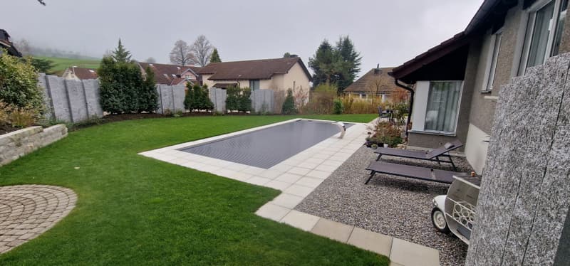 Garten mit Pool und Rollladen vor Einfamilienhaus