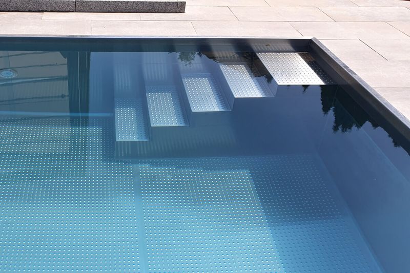 Edelstahl-Einbautreppe in einem hellen Becken