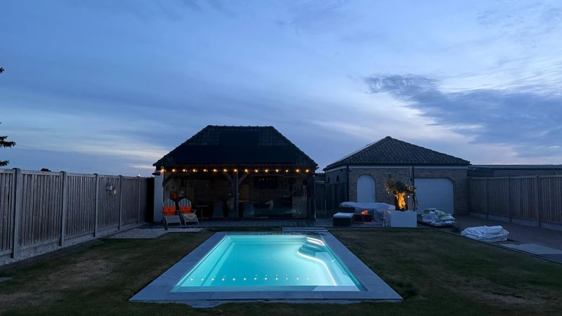 Herstellerfoto WaterRows WaterRows Single 78 in Antique Alabaster am Abend, beleuchtet vor einem Gartenhaus