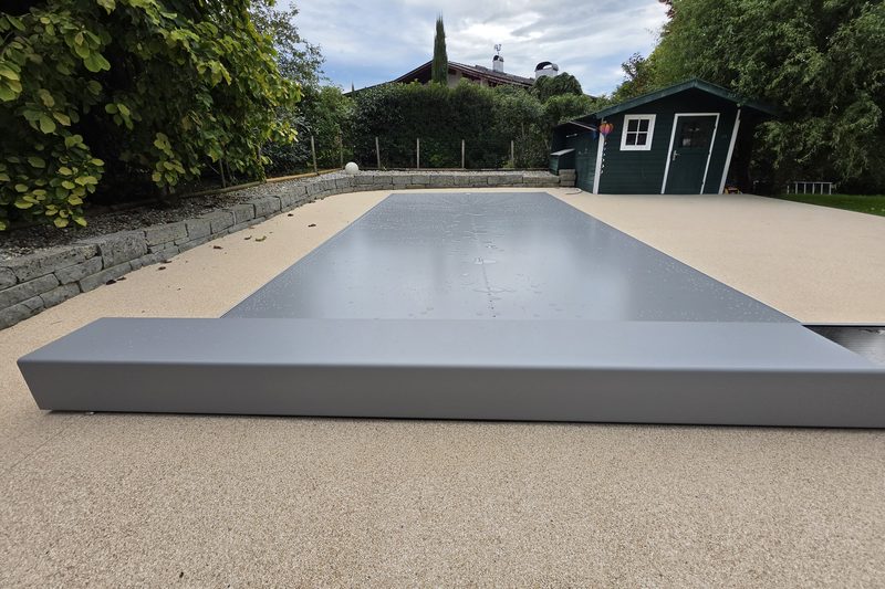Pool mit geschlossener Coverseal-Membran, vorne das Gehäuse am Beckenrand